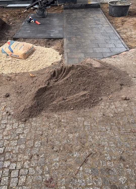 Fugenmaterial wird nach dem Verlegen in eine Pflasterfläche eingekehrt