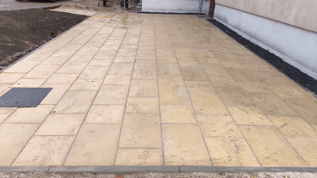 Terrasse aus Sandsteinplatten mit Kiesstreifen an der Hauswand